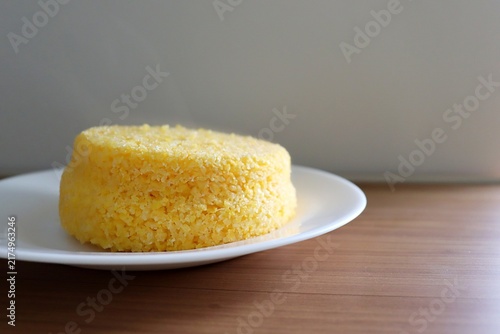 Brazilian couscous on a wooden background. Couscous (Cuscuz, in Portuguese) is a typical northeastern Brazil breakfast.
