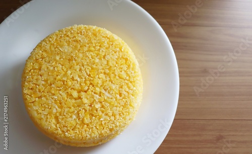 Brazilian couscous on a wooden background. Couscous (Cuscuz, in Portuguese) is a typical northeastern Brazil breakfast.