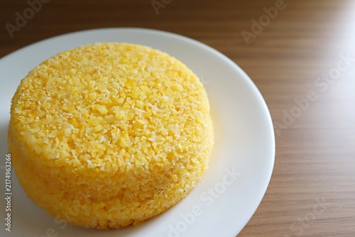 Brazilian couscous on a wooden background. Couscous (Cuscuz, in Portuguese) is a typical northeastern Brazil breakfast.