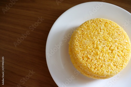 Brazilian couscous on a wooden background. Couscous (Cuscuz, in Portuguese) is a typical northeastern Brazil breakfast.