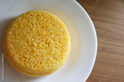 Brazilian couscous on a wooden background. Couscous (Cuscuz, in Portuguese) is a typical northeastern Brazil breakfast.
