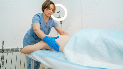Female physiotherapist massaging woman in rehabilitation center