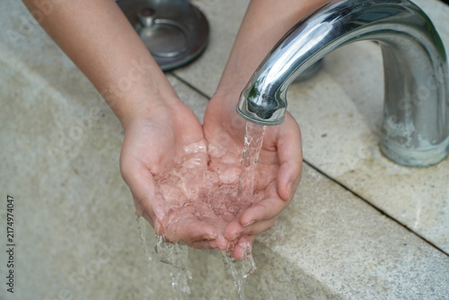 washing hands at home bathroom faucet,hygiene and cleanliness are essential for good health and prevention.