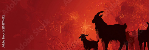 Silhouettes of goats stand against fiery red background. Fireworks burst behind them, glowing warmly. Scene suggests celebration or festival atmosphere. Ideal for holiday, cultural