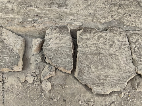Broken and cracked concrete pavement texture background, destroyed cement road surface close up