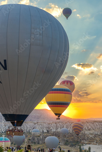 Hot air balloons flying over rocky valley at sunset. Hot air ballooning represents freedom exploration dream.