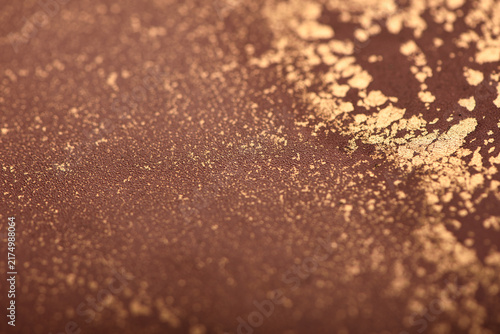 Artistic background featuring reddish-brown swirls with gold accents; photo of the surface.