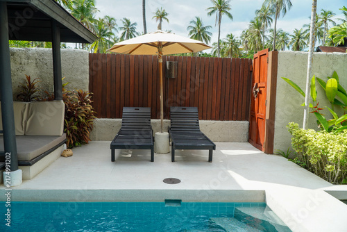 Private pool villa with sun loungers and poolside umbrellas.concept of a pool villa for relaxation.