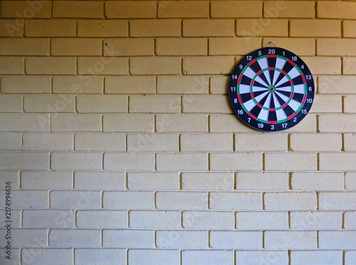Foto Dartboard on brick wall background and copy space for add text