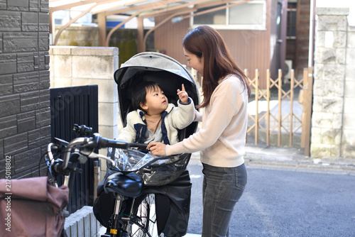 A young Asian mother with her child on a bicycle.