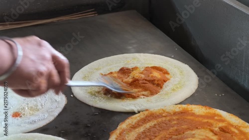 Traditional benne masala dosa being prepared on hot griddle close up