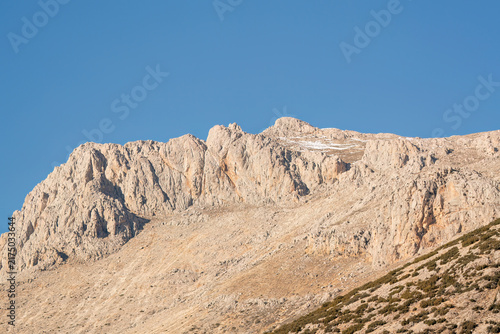 Foto Rugged limestone mountain peak under a clear blue sky in the Taurus Mountains, T