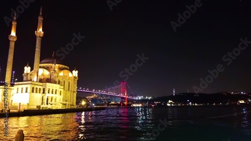 Scenic Night View of Ortakoy Mosque and the Illuminated Bosphorus Bridge Reflected on Water, Famous Historical Landmark and Sea View in Istanbul, Turkey