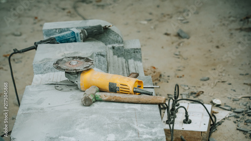 Fotografía Sculpting tools and angle grinder on stone slab at outdoor artisan workshop ston