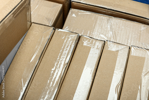 Courier shipments in cardboard boxes with labels wrapped with tape, shipping and delivery
