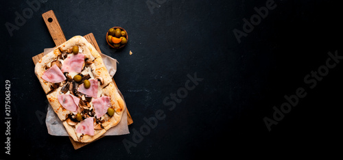 Pizza with ham and mushroom on wooden board, comfort food indulgence concept. Homemade Italian meal and rustic baking tradition. Delicious fast food recipe for your dinner.