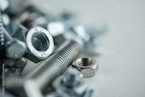 Close-up of metal nuts and bolts on a plain background
