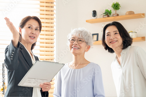 住宅内見で案内を受けるシニア女性と家族