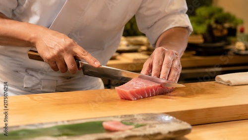 Plakat 寿司職人が新鮮なマグロのブロックを刺身用に丁寧に捌く手元