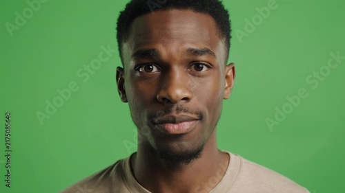Man's diverse facial expressions changing quickly in studio lighting against a green screen background