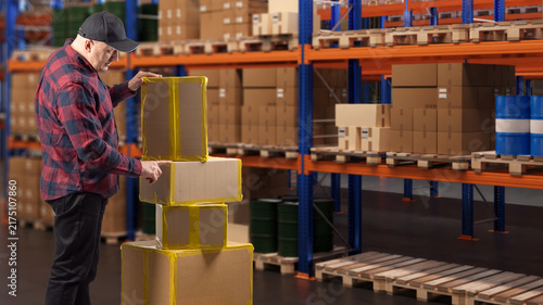 Obraz na płótnie Warehouse logistics, worker handles cardboard boxes in a storage facility, preparing packages for inventory, distribution and shipment