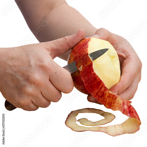 Hands peeling red apple with knife isolated on white