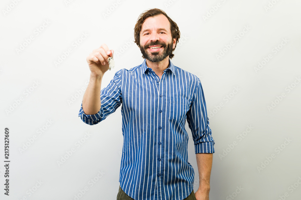 Fototapeta premium Adult man holding keys, symbolizing home purchase, property investment, mortgage and housing