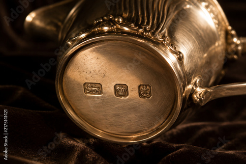 Antique silver cream jug with hallmark stamps on dark velvet, craftsmanship and heritage concept