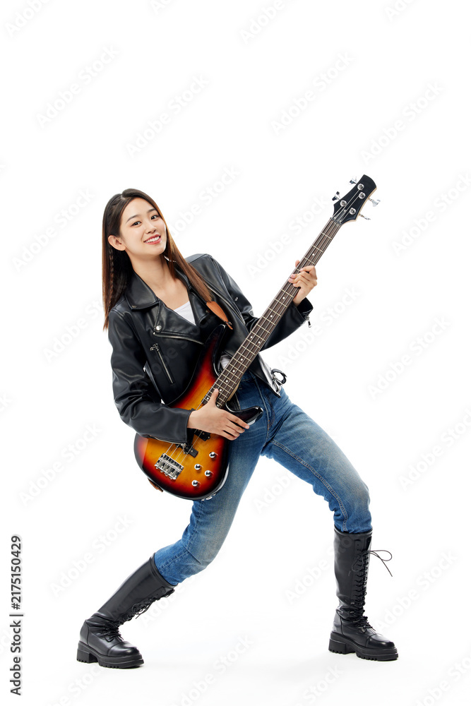 Fototapeta premium Energetic young woman playing bass guitar in rock pose on white