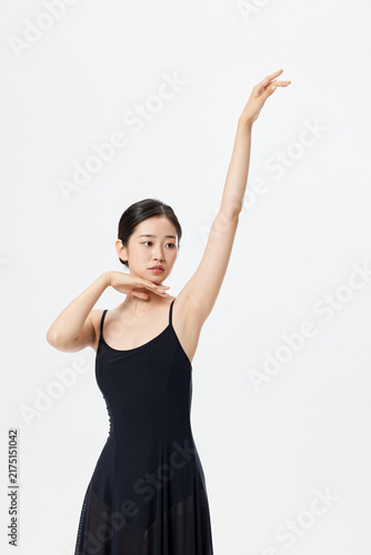 фотографія Graceful young ballerina posing in black leotard in studio