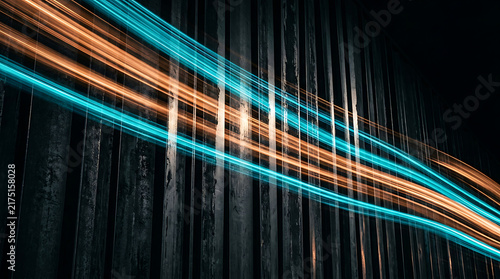 Abstract light streaks move across dark industrial background with vertical lines in cool colors.