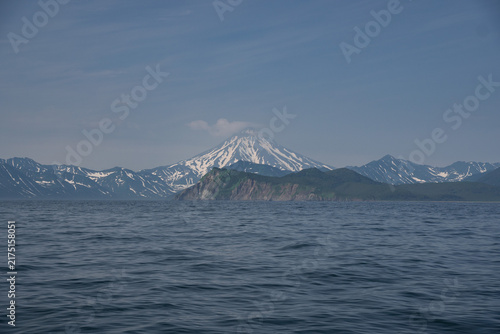 Canvastavla Vilyuchinsky Volcano towers above distant mountain ridges and rolling Pacific water in Avacha Bay, Kamchatka, Russia