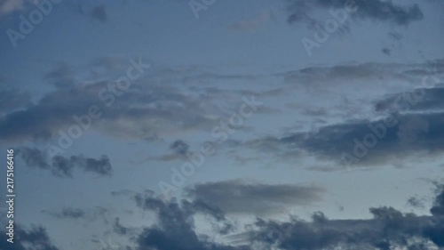 Dusk sky filled with moving dark blue and grey clouds under soft evening light, creating a serene and moody atmospheric background.