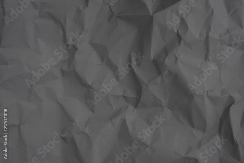 Crumpled paper texture with sharp creases, deep folds, and soft shadows in dark gray tones