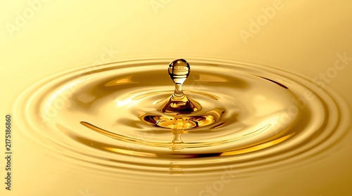 Golden Liquid Droplet Impacting Surface Creating Ripples.