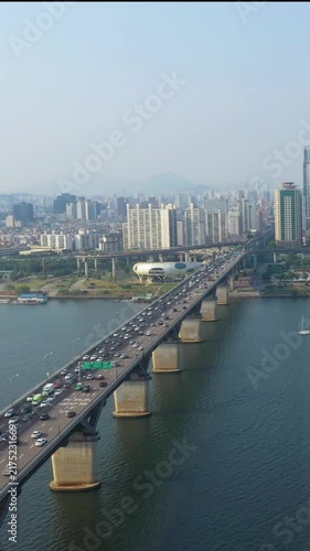 Aerial view from a drone. Vertical video of traffic on a bridge over the Han River in Seoul, South Korea.