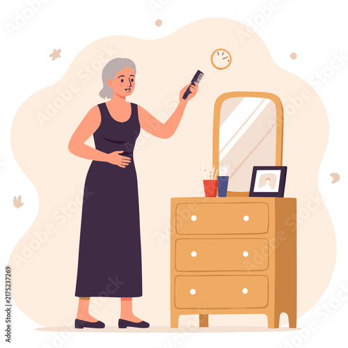 Older woman looking at her phone while standing by a dresser. Elderly set  