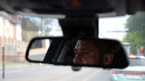 Bild auf Leinwand Eyes of male driver reflecting in rearview mirror while riding motor auto