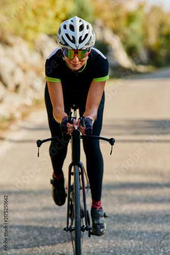 Fotografía Female Cyclist Riding Road Bike in Aerodynamic Position on Rural Road Training f