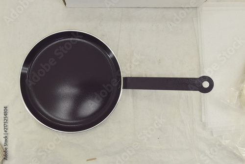 Fotografie Black frying pan viewed from above against a clean light background, emphasizing its circular shape and cooking surface