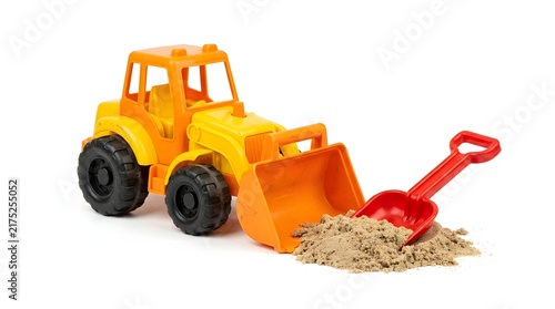 Plastic toy bulldozer with a red shovel and a small pile of sand for children to play with in the backyard or at the beach