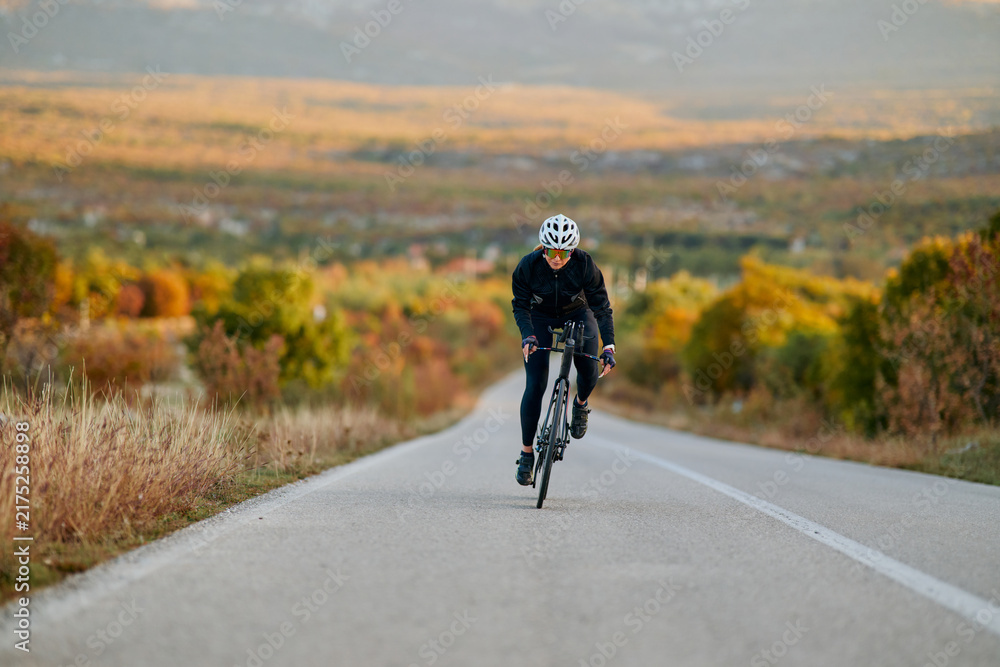 Fototapeta premium Road Cyclist Training On Scenic Autumn Highway At Sunrise Fitness Cycling Athlete Outdoor Endurance