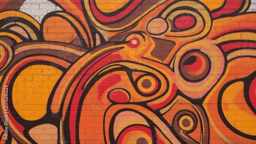 Vibrant abstract graffiti mural with colorful swirling patterns on a brick wall