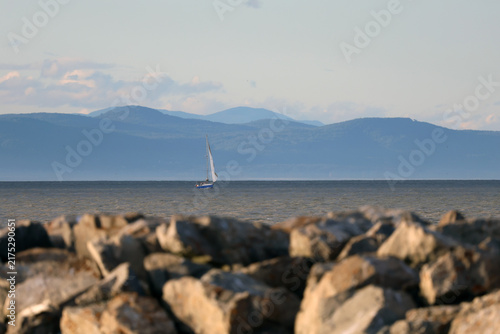 Konstfotografi Voilier en mer sur fond de montagnes et de ciel bleu