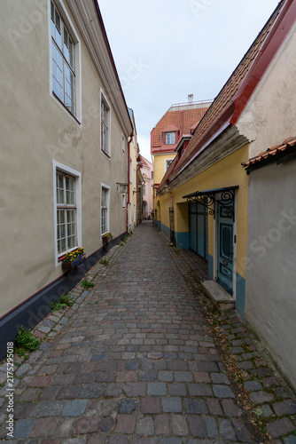 Narrow cobblestone alley with historical buildings in Tallinn Old Town, Estonia