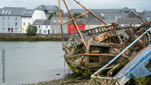 Foto Exposed structure of coastal decay fills the frame with collapsed timber, rusted spars and algae on old boat wrecks before the Long Walk in Galway for maritime texture and heritage features