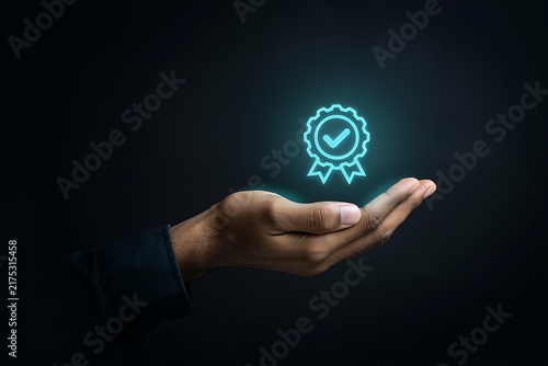 Person hand holding glowing certificate badge with checkmark symbol for quality assurance