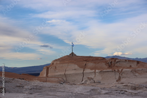 Fotografie Argentine Flag Above the Eroded Rock Formations of Campo de Piedra Pómez