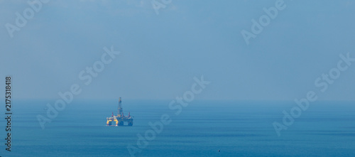 Foto Offshore drilling platform stationed on calm open sea