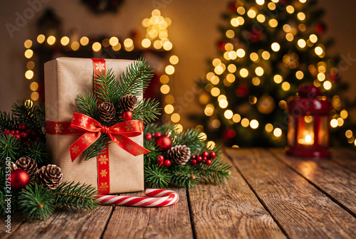 Rustic Wrapped Christmas Gift Box on Wooden Table with Bokeh Tree Lights